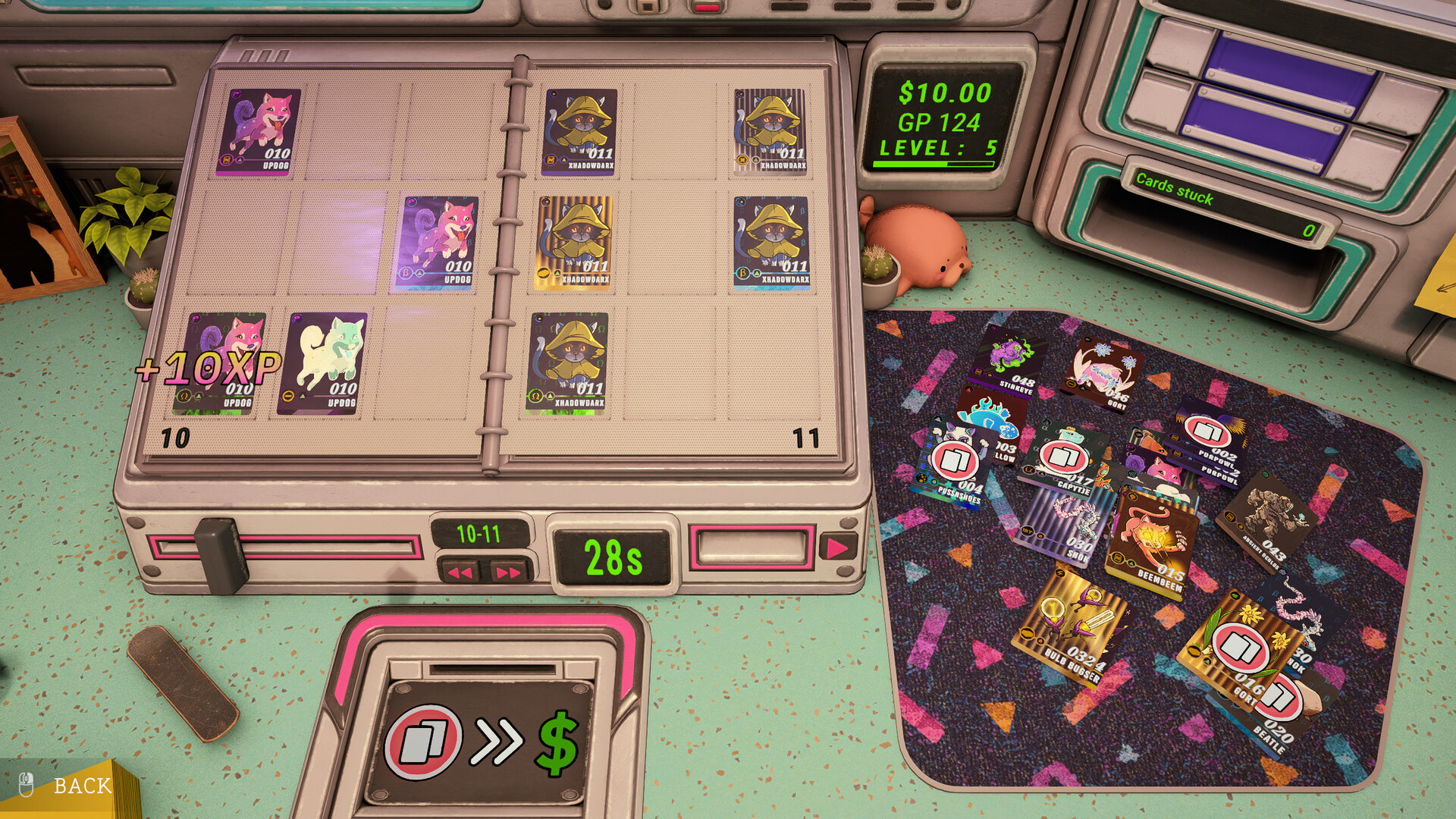 The workstation with an open binder of Critkin cards on the left, loose cards on the playmat, and the card disposal chute on the front edge of the desk.